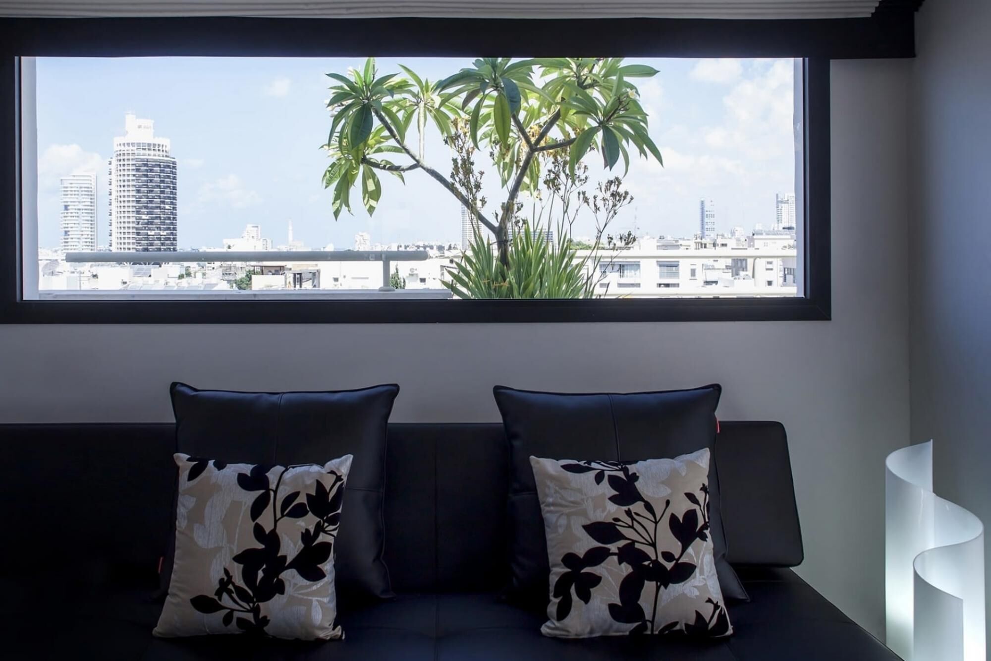 A modern living room with a large window overlooking a cityscape.