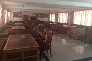 Una habitación amplia con una mesa de comedor grande, varias sillas, un sofá y una televisión.