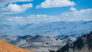 Un paysage montagneux, avec un ciel dégagé et des sommets lointains.
