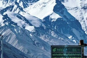 Un paisaje montañoso con un cartel en primer plano.