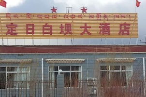 A building with a large signboard, multiple windows, and a flag.