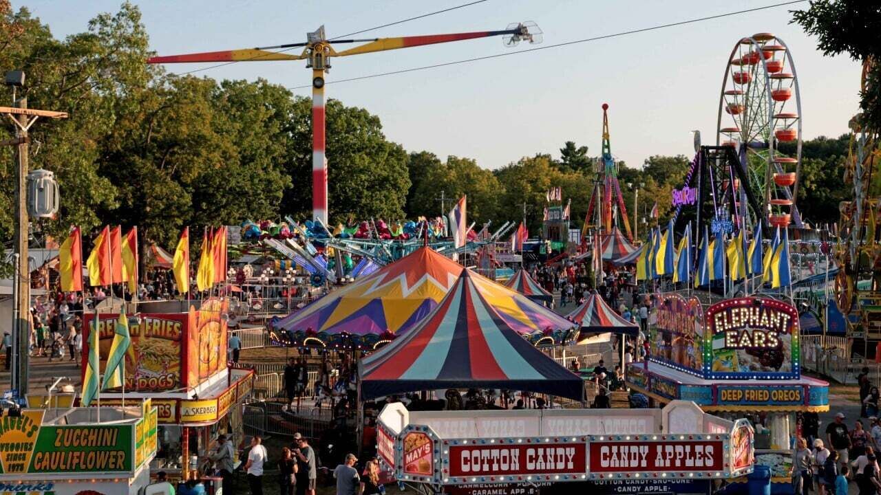 A carnival with rides, tents, and food stalls.
