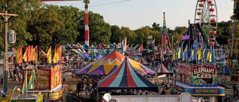 A carnival with rides, tents, and food stalls.