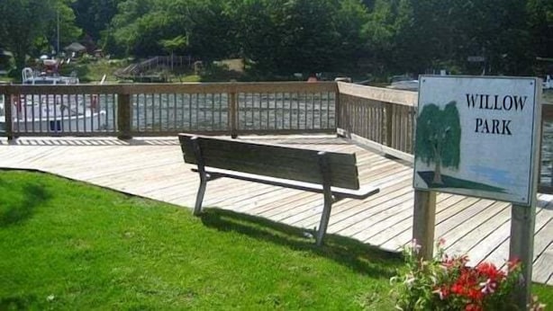 A park with a wooden deck, a bench, and a sign that reads 'WILLOW PARK.' - Anchors Away: Nautical downtown Saugatuck abode with balcony and partial river views (Saugatuck)