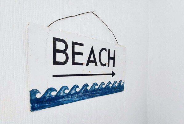Un letrero con la palabra 'BEACH' y una flecha que apunta a la derecha.