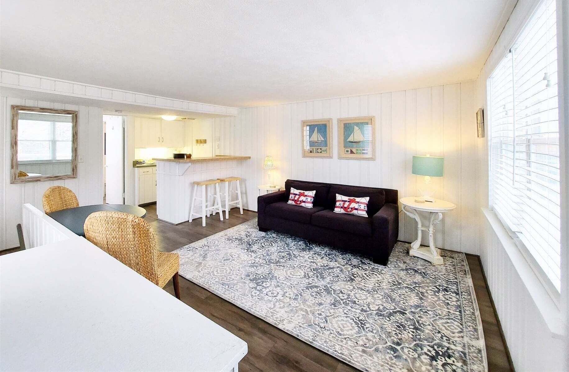 Un espacio habitable compacto con sofá, mesa de comedor y zona de cocina.