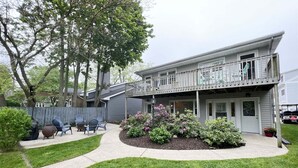 A two-story house with a covered porch, a fenced backyard, and a well-maintained lawn.