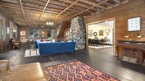 A rustic interior with a stone fireplace, wooden beams, a pool table, and a dining area. - Pine Lodge: Lake Michigan Beach Access, Private Swimming Pool & Hot Tub, Sauna (Glenn)