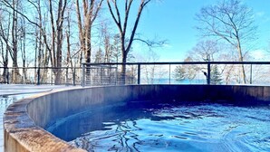 A swimming pool with a curved edge, surrounded by a metal railing and trees. - Pine Lodge: Lake Michigan Beach Access, Private Swimming Pool & Hot Tub, Sauna (Glenn)