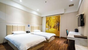 A hotel room with two beds, a wooden floor, a painting of a tree-lined path, a desk with a chair, and a mirror. - Linhai H Chain Lihao Star Hotel (Linhai)