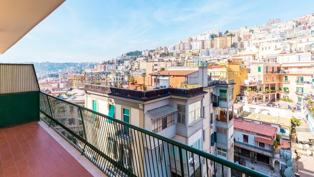 A balcony with a view of a densely packed urban area with various buildings and a clear sky. - Chiaia Mon Amour Elegant Flat by Napoliapartments (Naples)