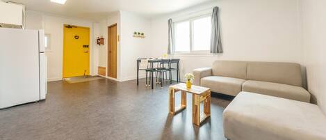 A compact living space with a kitchenette, a dining area, and a seating area.