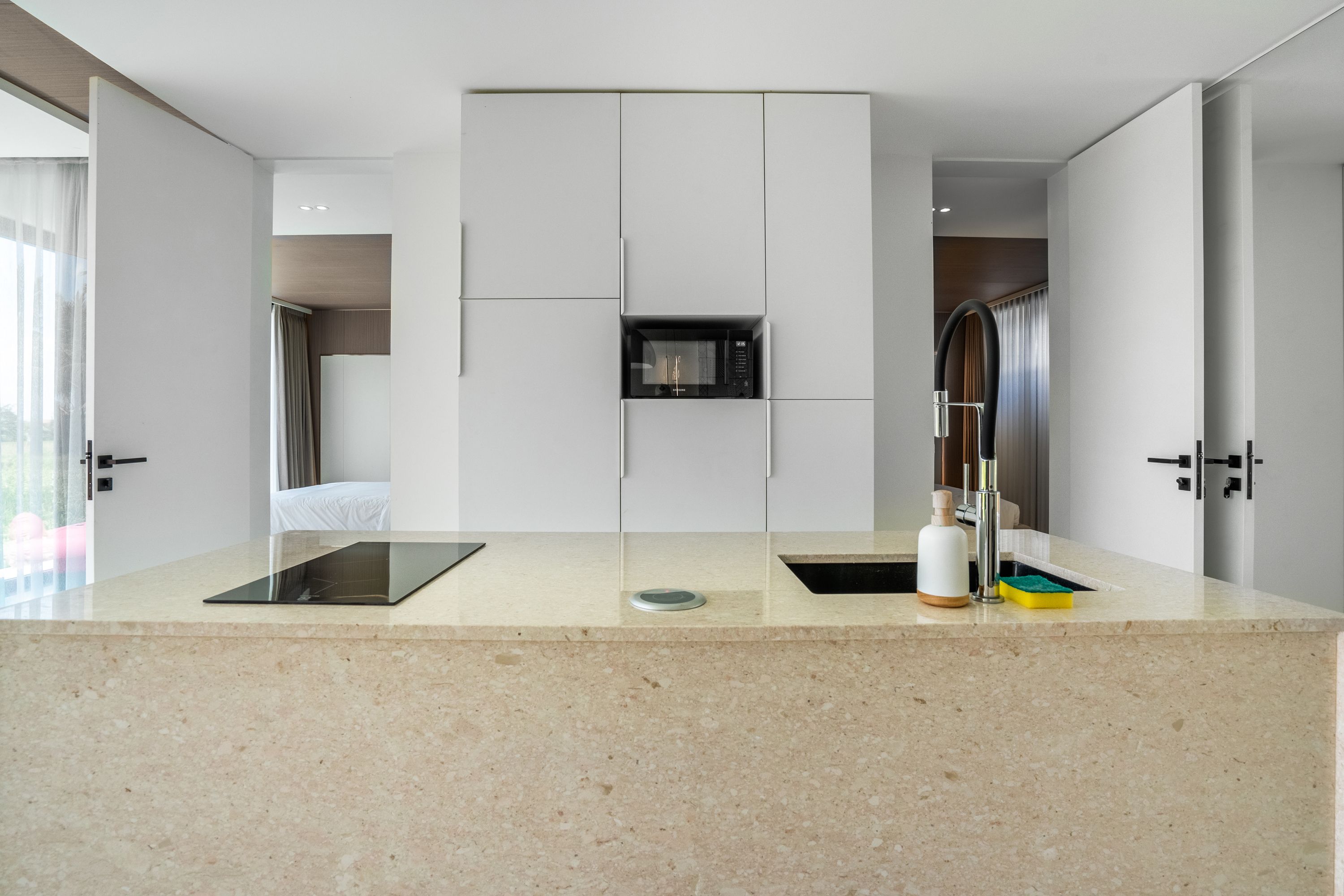 A modern kitchen with a built-in microwave, a sink, and a countertop.