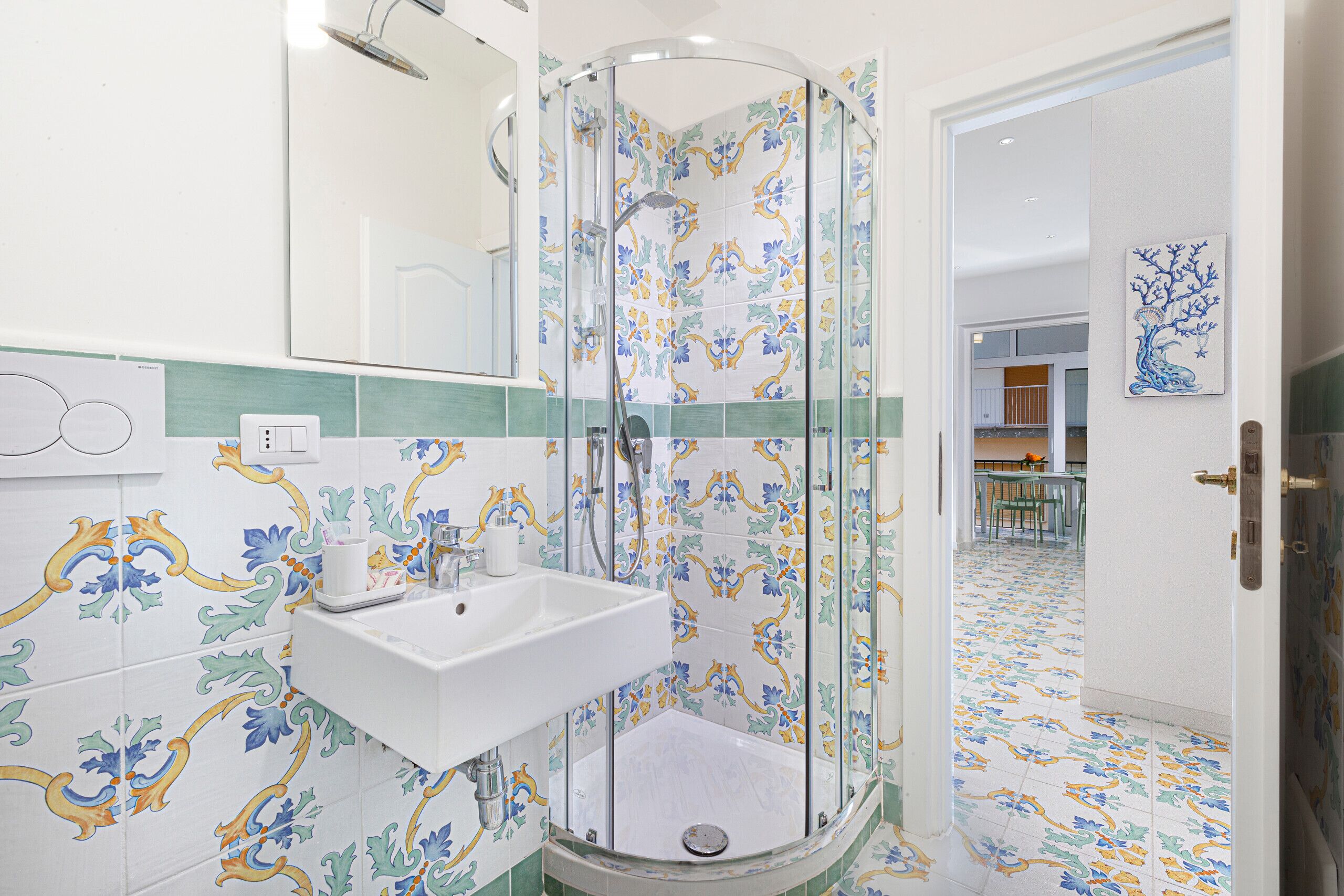 A bathroom with a glass-enclosed shower, a sink, and a mirror.