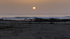 A beach with the sun setting over the ocean. - Beachfront apartment, with sea and pool view, in El Cotillo, Fuerteventura (El Cotillo, La Oliva)