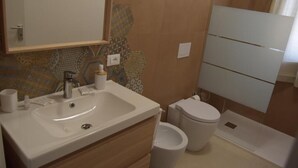 A bathroom with a sink, toilet, and mirror. - Brand new apartment and strategically located. (Terrasini)