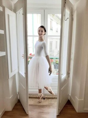 A person in a white ballet outfit standing in a doorway. - Beautiful Family Apartment in Leiria (Leiria)