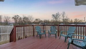 A wooden deck with two green Adirondack chairs facing a view of houses and trees under a clear sky. - Abby's Place - Close to Attractions (Branson)