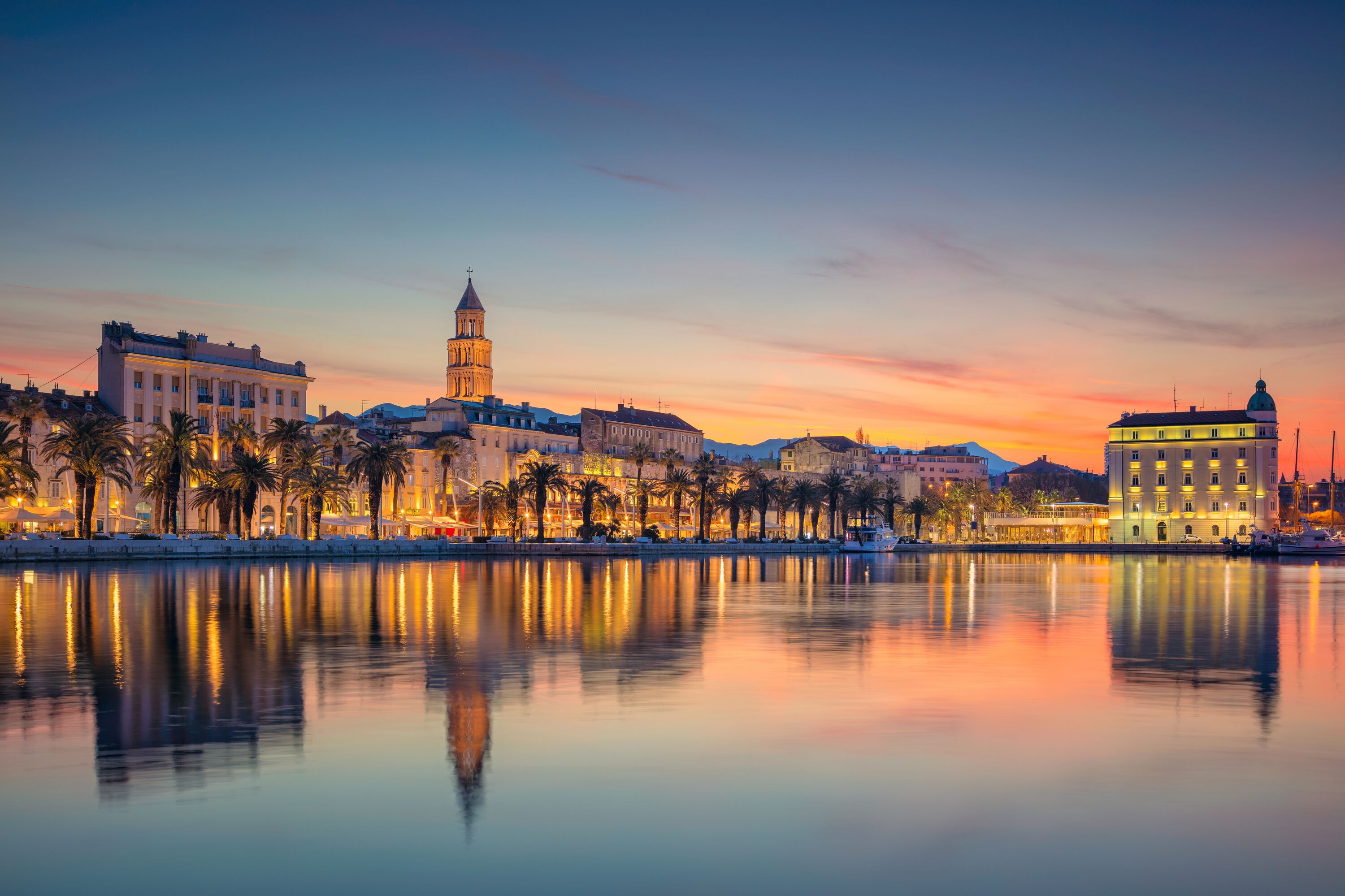 A waterfront cityscape with a prominent tower and buildings along the shore.