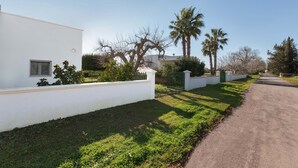 Un edificio moderno blanco con un camino pavimentado y un césped bien cuidado.