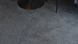 Ein kleiner, runder Glastisch mit zwei Stühlen, einer wandmontierten Lampe und einer herzförmigen Dekoration.