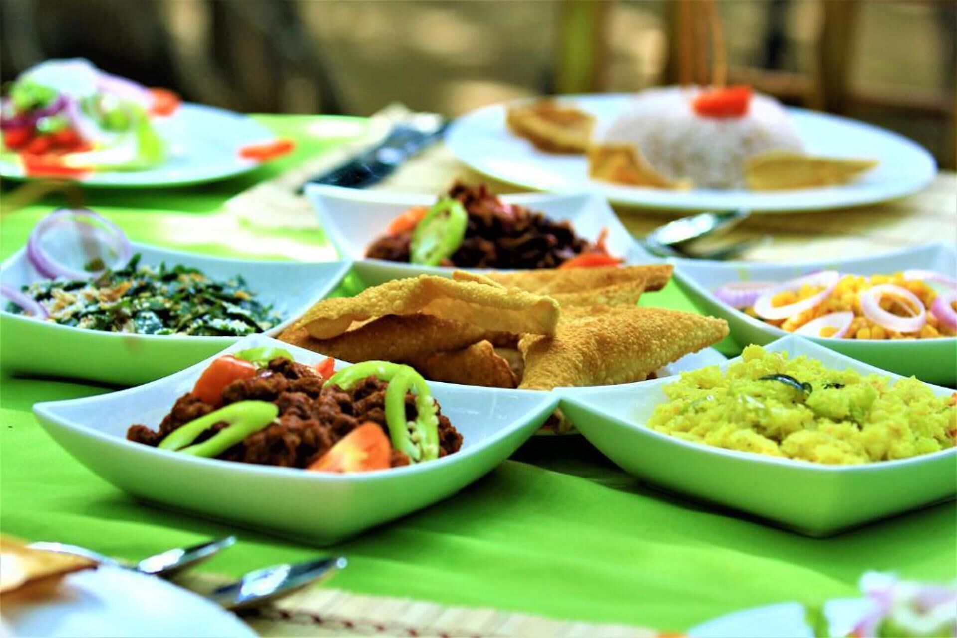 Ein Tisch mit verschiedenen Gerichten in Schalen, darunter vermutlich ein Salat, ein Gericht mit Fleisch und ein Reisgericht.
