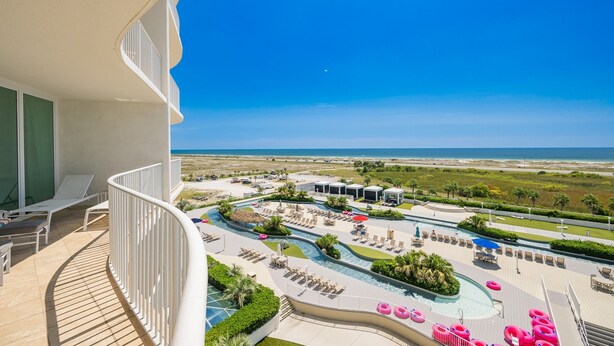 A resort with a pool area, lounge chairs, and a view of the beach. - Caribe The Resort D614 3 Bedroom Condo (Orange Beach)