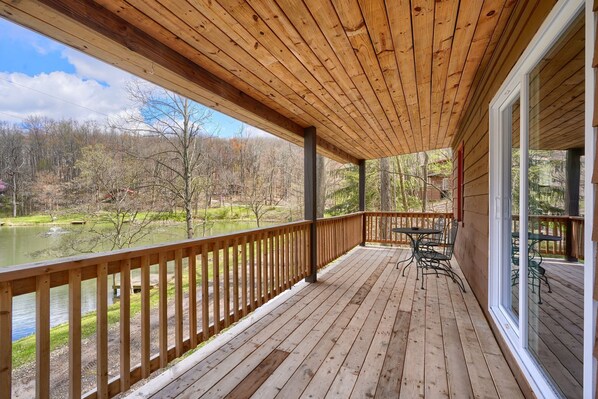 A wooden deck with a view of a lake and forest.