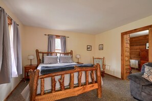 A bedroom with a wooden bed frame, a nightstand, a chair, and a wooden wardrobe.