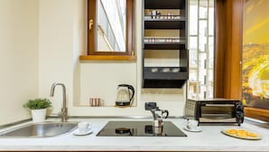 Une cuisine équipée d’un évier, d’une machine à café, d’un grille-pain et d’une fenêtre donnant sur la ville.