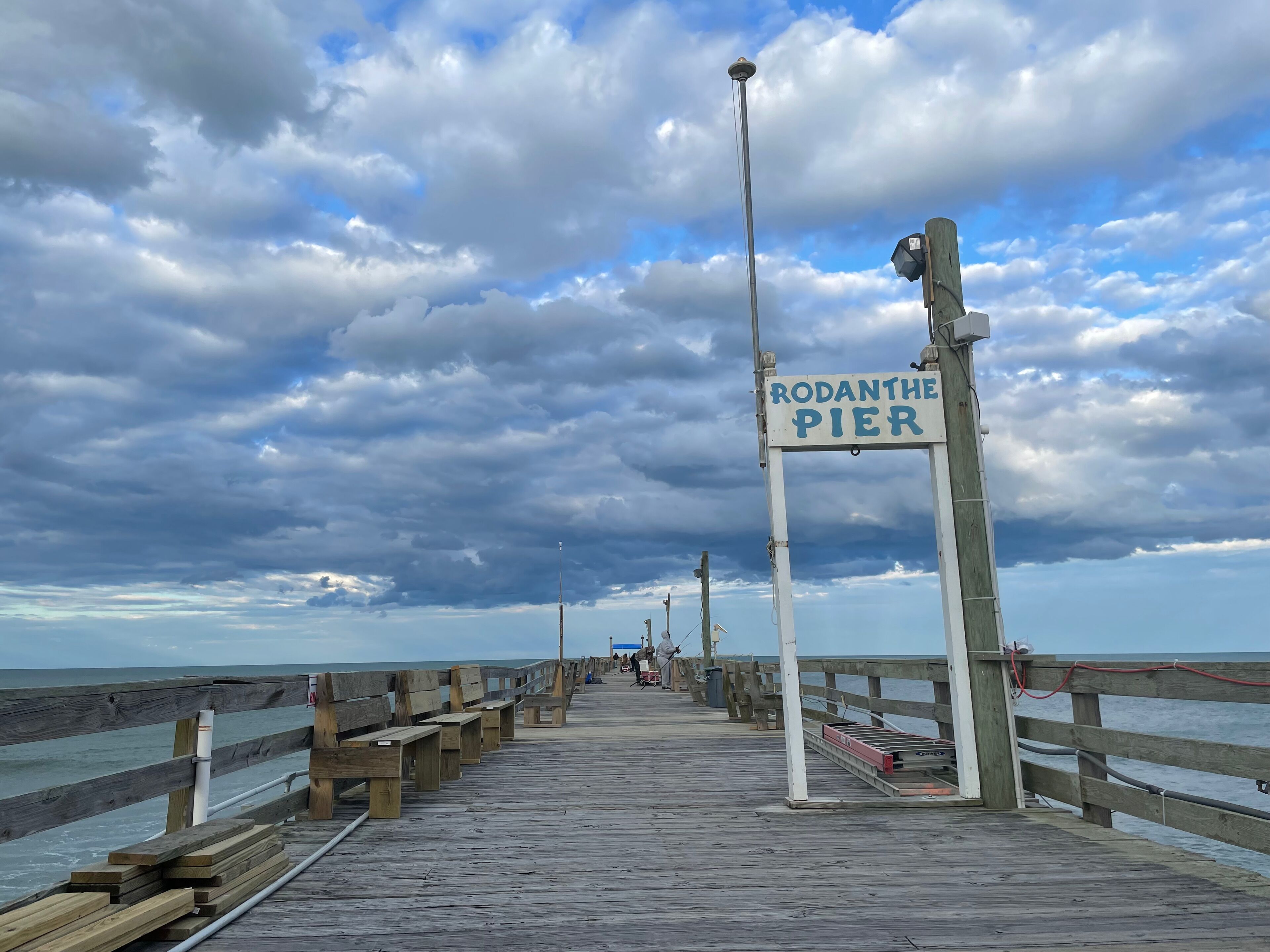 Une jetée en bois, sur laquelle on peut lire l’inscription « JETÉE DE RODANTHE », s’avance dans la mer.