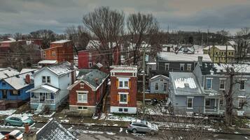 A residential area with houses, some with snow on the roofs and ground.