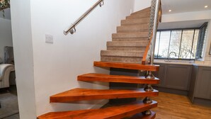 Un escalier moderne avec des marches en bois et des rampes en métal.