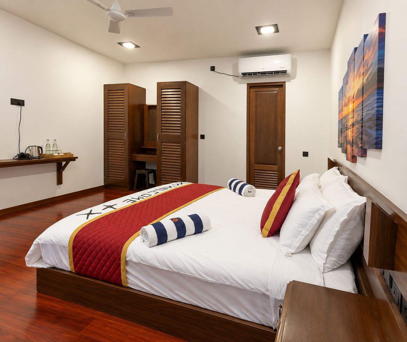 Una habitación de hotel con cama, armario de madera, unidad de aire acondicionado y un cuadro en la pared.