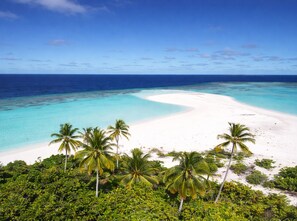 A tropical beach with white sand, clear turquoise water, and palm trees. - Suncoral Maldives (Kondey)