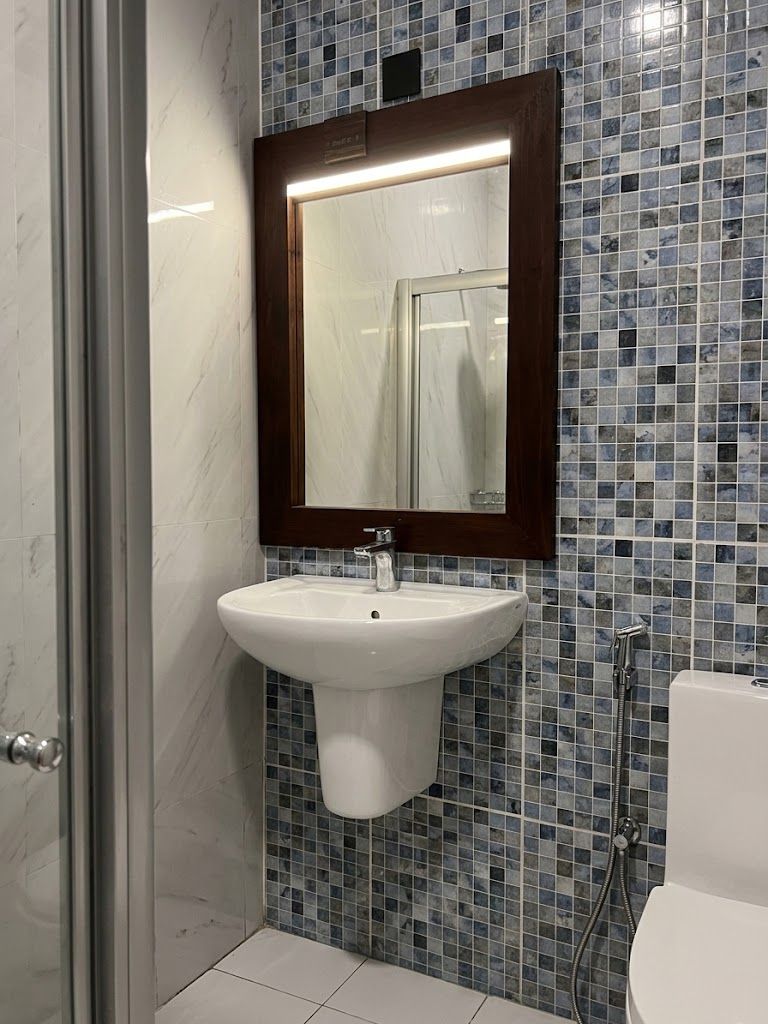 A bathroom with a white sink, a mirror, and a shower.