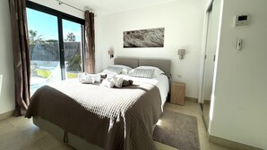 A bedroom with a large bed, a view of the outdoors, and a ceiling fan. - Capleouna- La Cabane, 3 bedrooms, Cap d'Antibes. (Antibes)