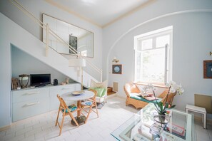 Un espace de vie lumineux et spacieux, comprenant un escalier, une table à manger et un coin salon confortable.