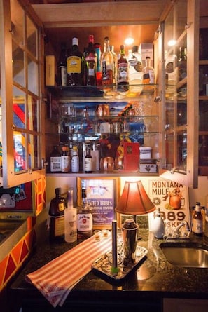 Enjoy a drink at the bar, where a selection of fine liquors is on display.