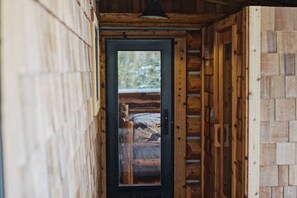 Stylish hallway leads to an outdoor deck with a wooden railing.