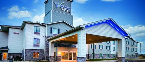 Un hotel con una torre destacada y un acceso cubierto.