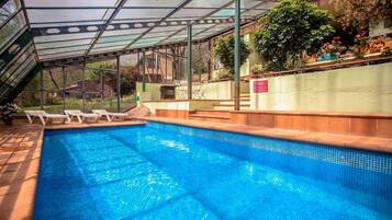 Una piscina al aire libre, una piscina climatizada