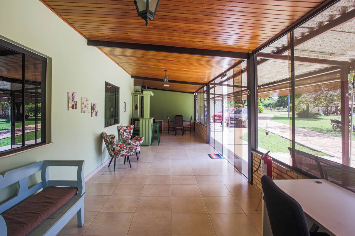 A spacious hallway with a wooden ceiling, a bench, and a table with chairs.