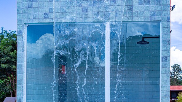 A modern building with a pool, featuring a water feature and a glass facade. - Villaggio dos Pássaros (Paranoa)
