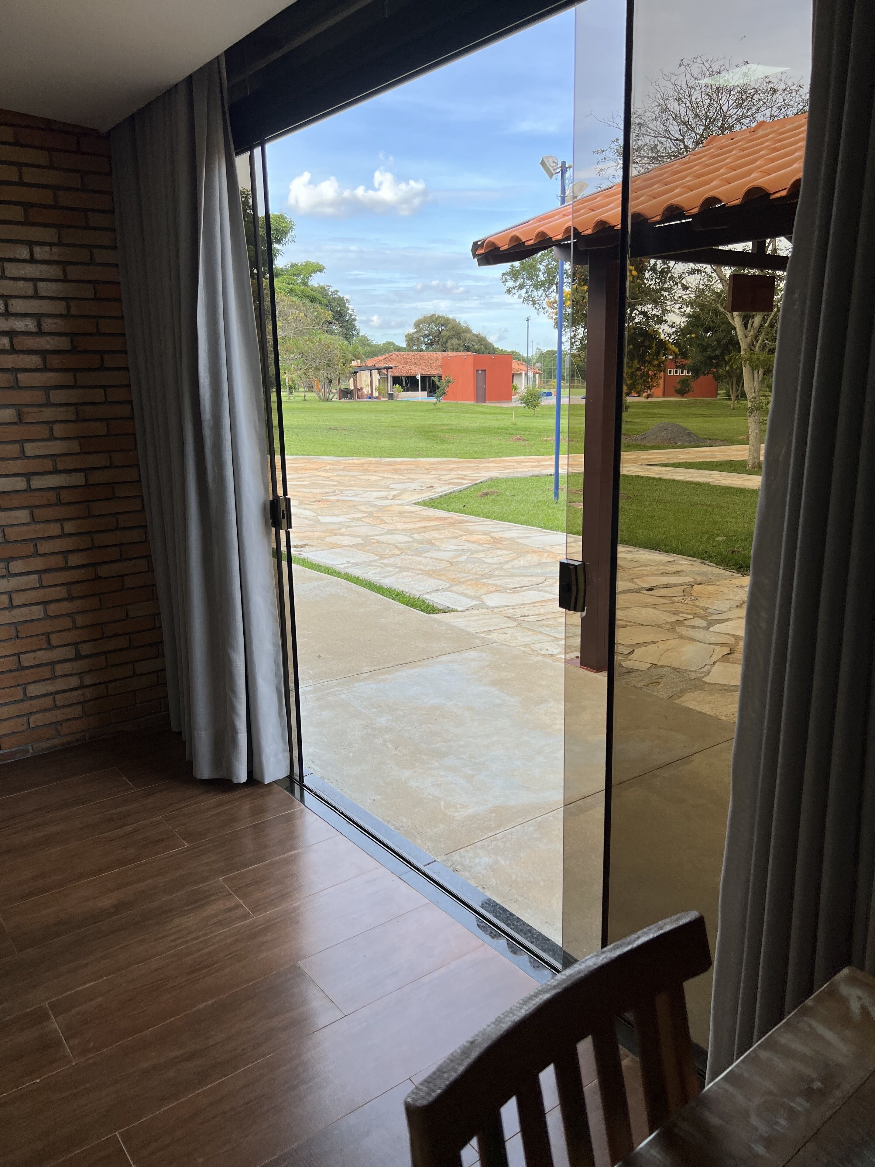 A room with a sliding glass door leading to a patio with a stone pathway and a grassy area.