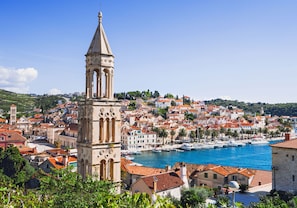 A coastal town with a prominent tower, red-roofed buildings, and a marina with boats. - Inviting Apartment 7 Sleeps 4 Guests (Split)