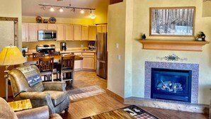 Un salón amplio con chimenea, un comedor y una cocina al fondo.