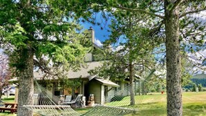 A house with a hammock in the yard, a porch with chairs, and a mountain backdrop. - Big Sky Bungalow - Center of Big Sky (Big Sky)