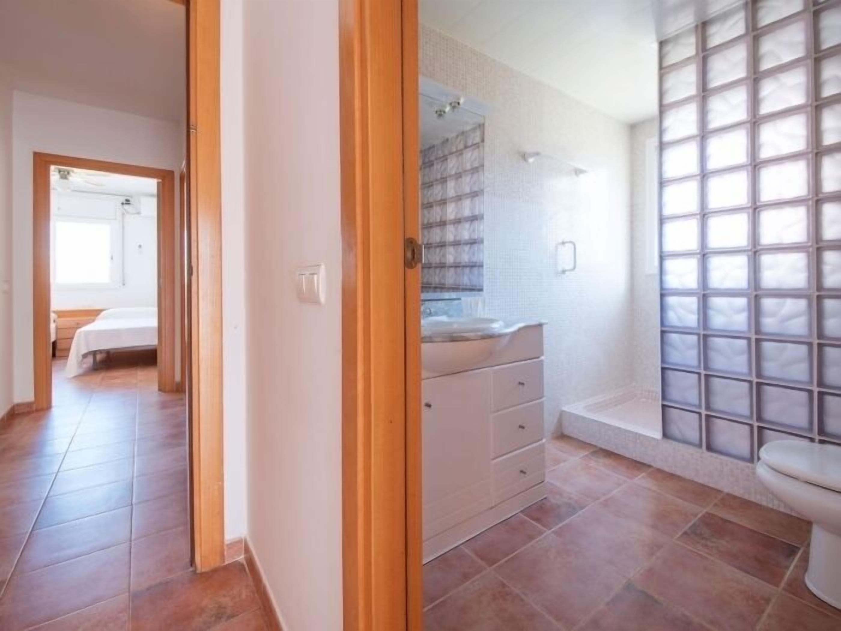A bathroom with a toilet, a sink, and a shower area.
