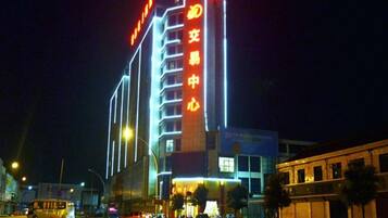 A multi-story building with illuminated signage, a flat facade, and a corner location.